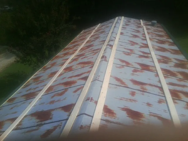 Rusted metal roof panels with new wood purlins before replacement — Storm Damage Roof Repair in Spottsville by Roofing Brothers