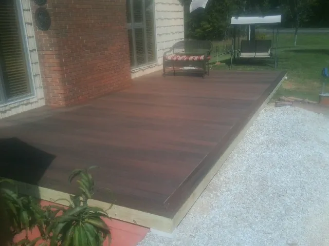 Freshly stained wood deck built against a brick home in Spottsville
