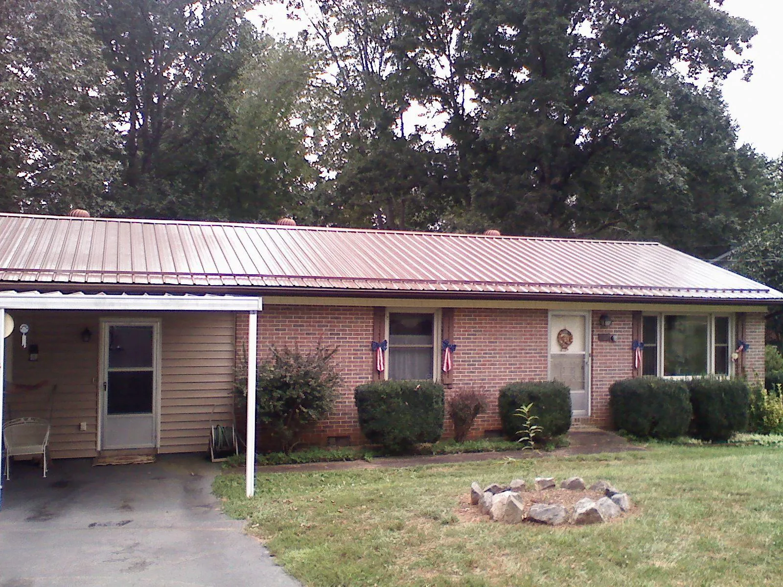 Bronze metal roof and carport on a brick ranch home — Roof Repair work by our crew in Spottsville
